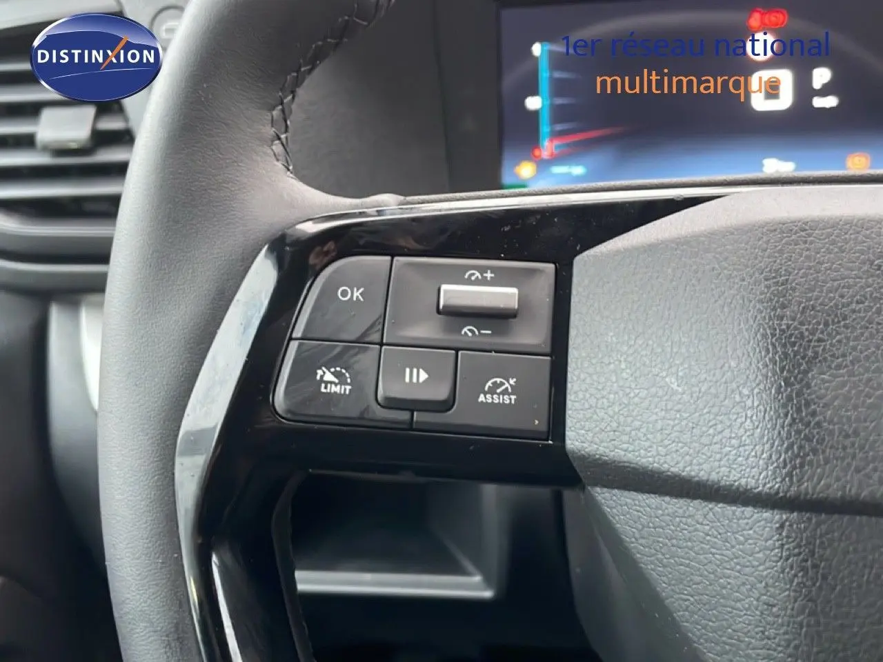 Gros plan sur les commandes à gauche du volant en cuir noir du Citroën Jumpy Long gris titane, avec affichage numérique en arrière-plan.