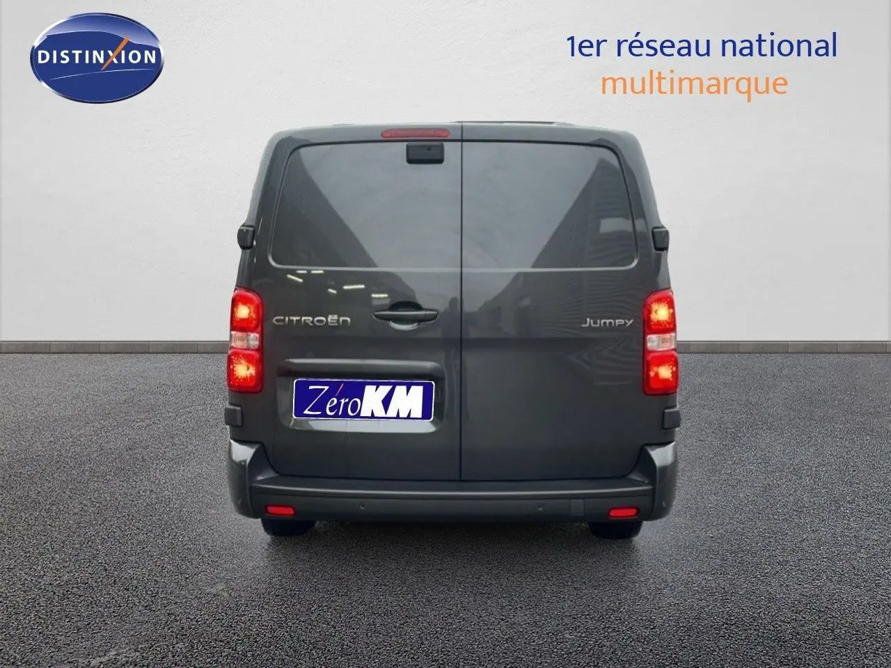 Vue arrière du Citroën Jumpy Cabine Approfondie gris titane métal avec feux allumés sur sol goudronné.