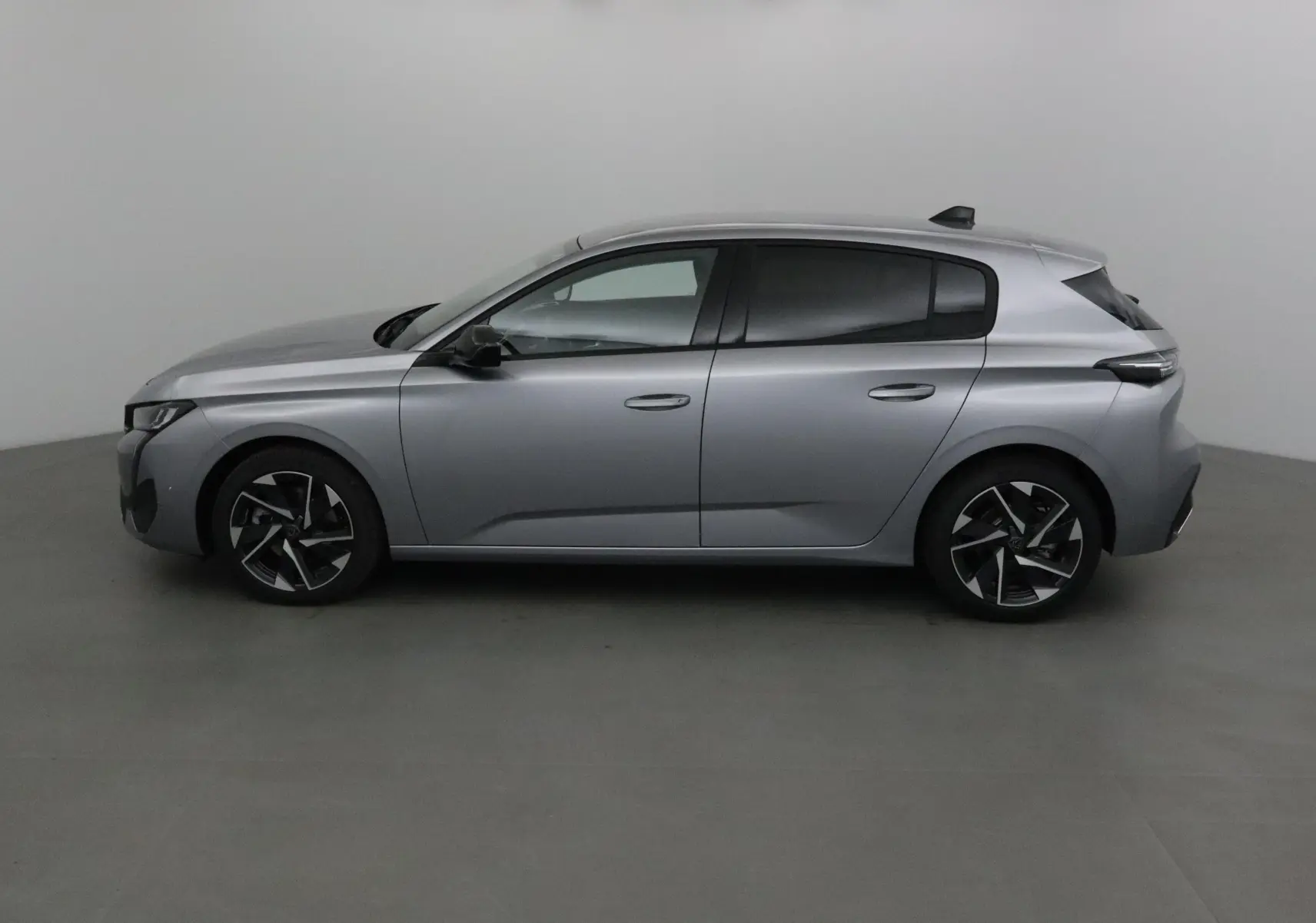 Peugeot 308 gris Artense vue profil côté gauche, mettant en valeur ses jantes alliage et lignes modernes.