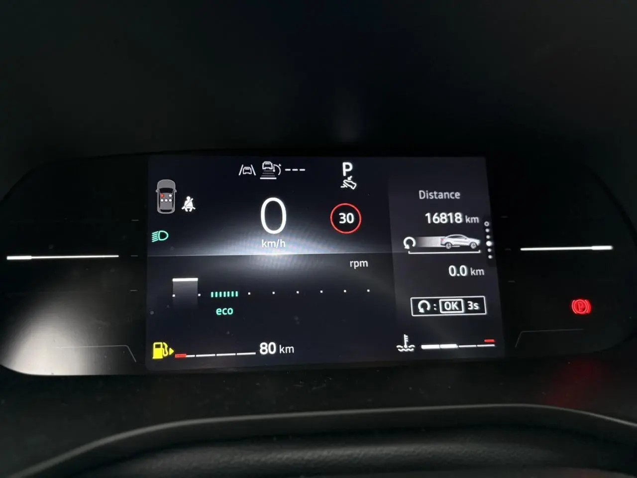 Tableau de bord numérique de Renault Arkana 2025 affichant vitesse, autonomie et alertes, vue frontale rapprochée.