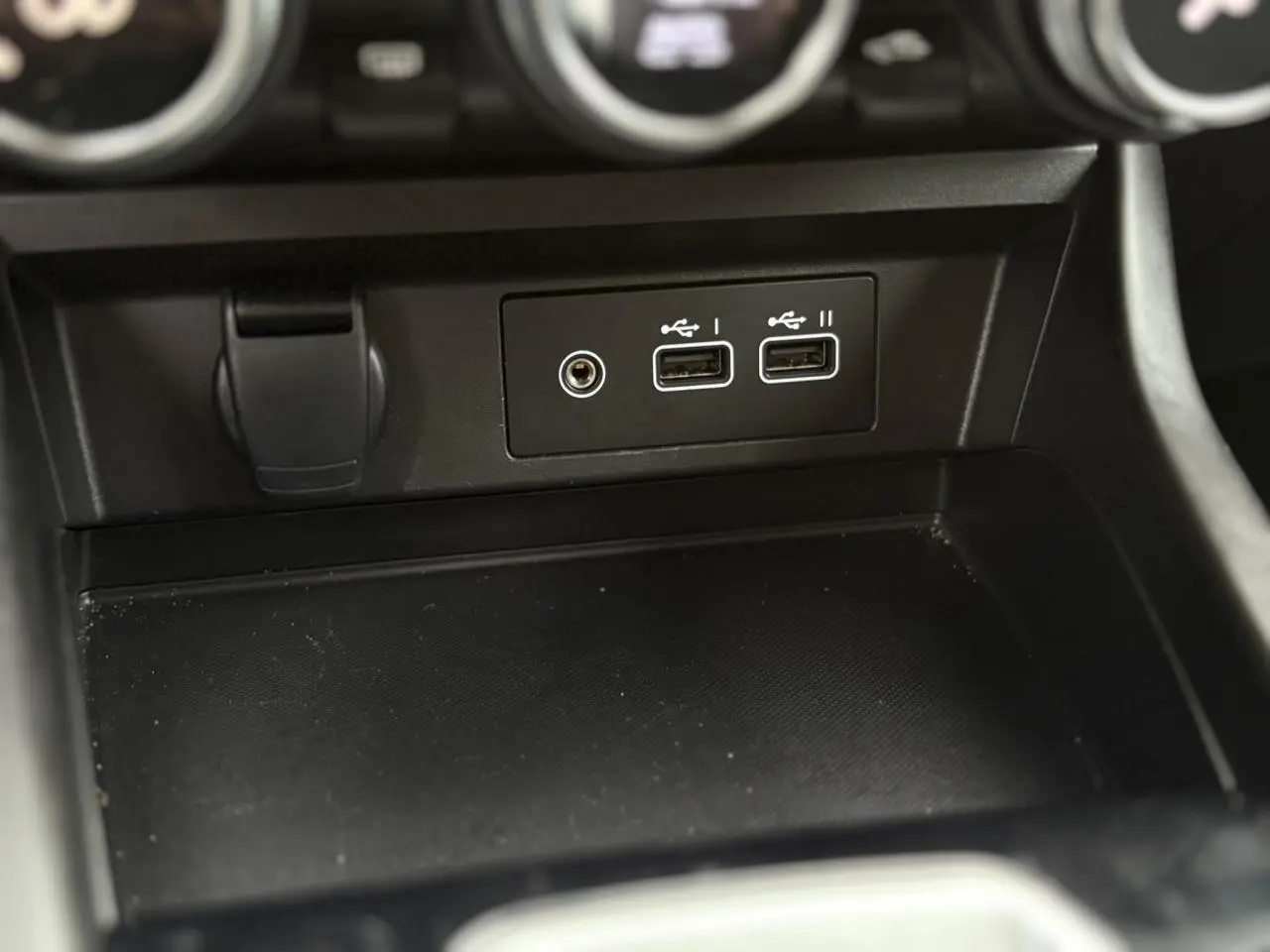 Vue rapprochée de la console centrale noire avec ports USB et prise jack du Renault Arkana TCE 140 EDC MHEV Evolution.