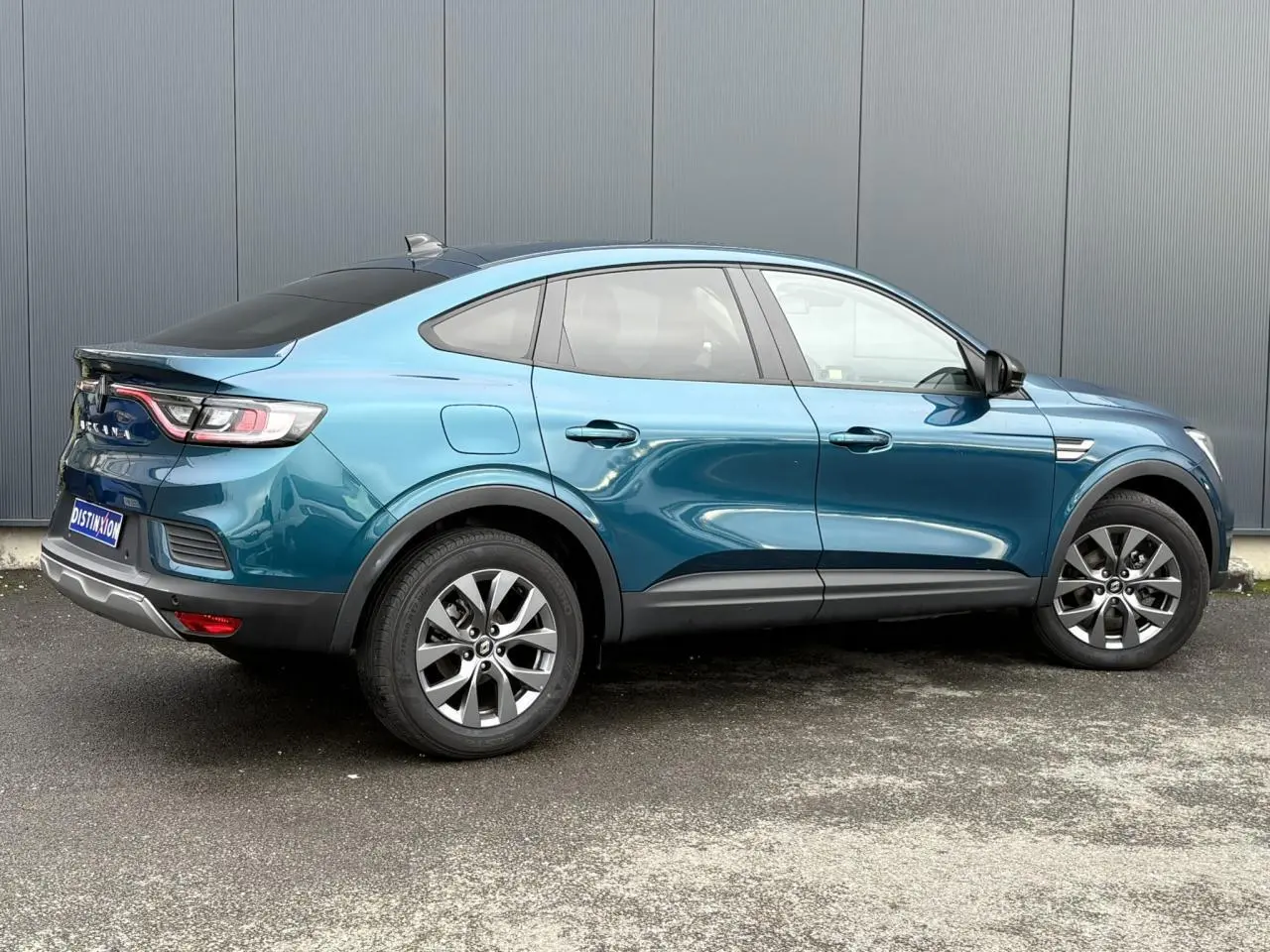 Renault Arkana bleu Zanzibar en vue profil droit, avec jantes alliage grises et vitres arrière surteintées.