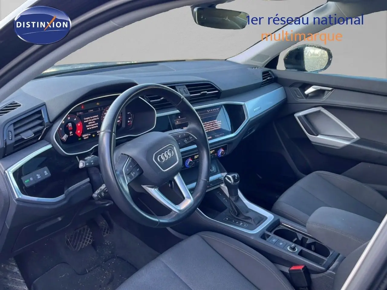 Intérieur de l'Audi Q3 Sportback noir 2022, vue côté conducteur, tableau de bord et console centrale avec écran tactile.
