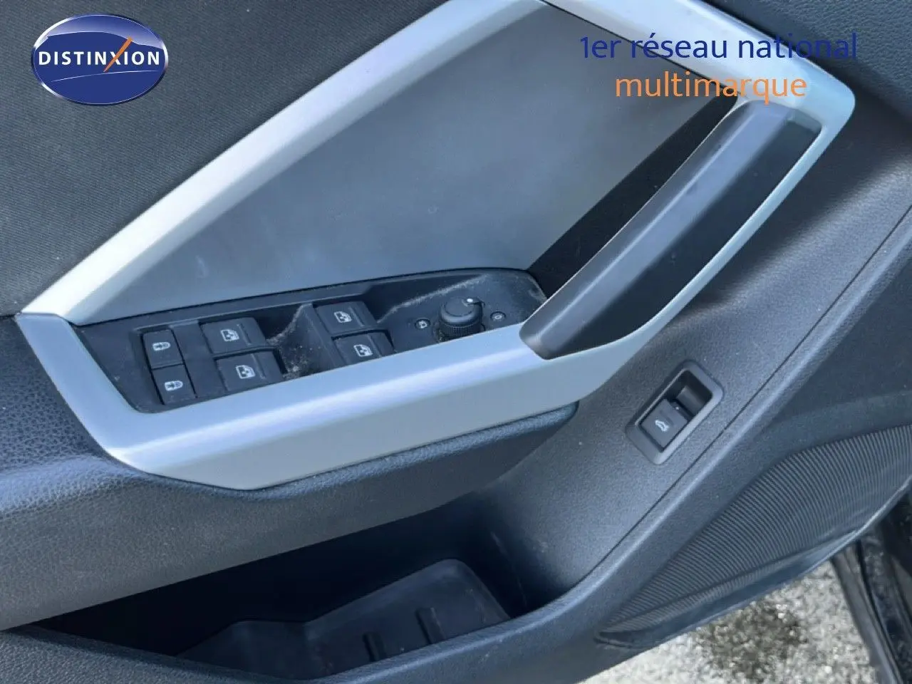 Détail de la porte côté conducteur de l'Audi Q3 Sportback noir, montrant les commandes des vitres et le bouton de déverrouillage.
