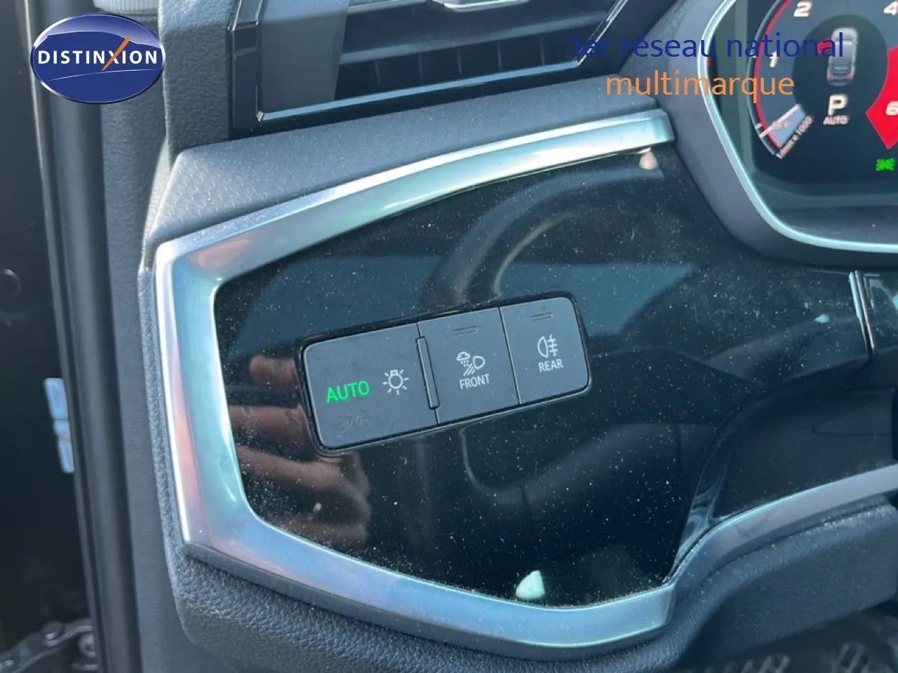 Gros plan sur les commandes d'éclairage intérieures d'un Audi Q3 Sportback noir, avec bouton auto allumé.