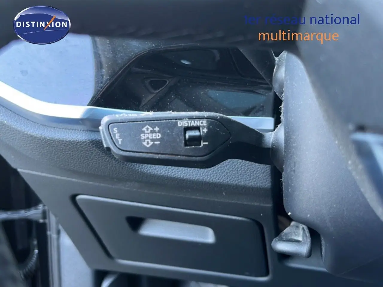 Gros plan sur la commande de régulateur de vitesse d’un Audi Q3 Sportback noir, côté gauche du volant.