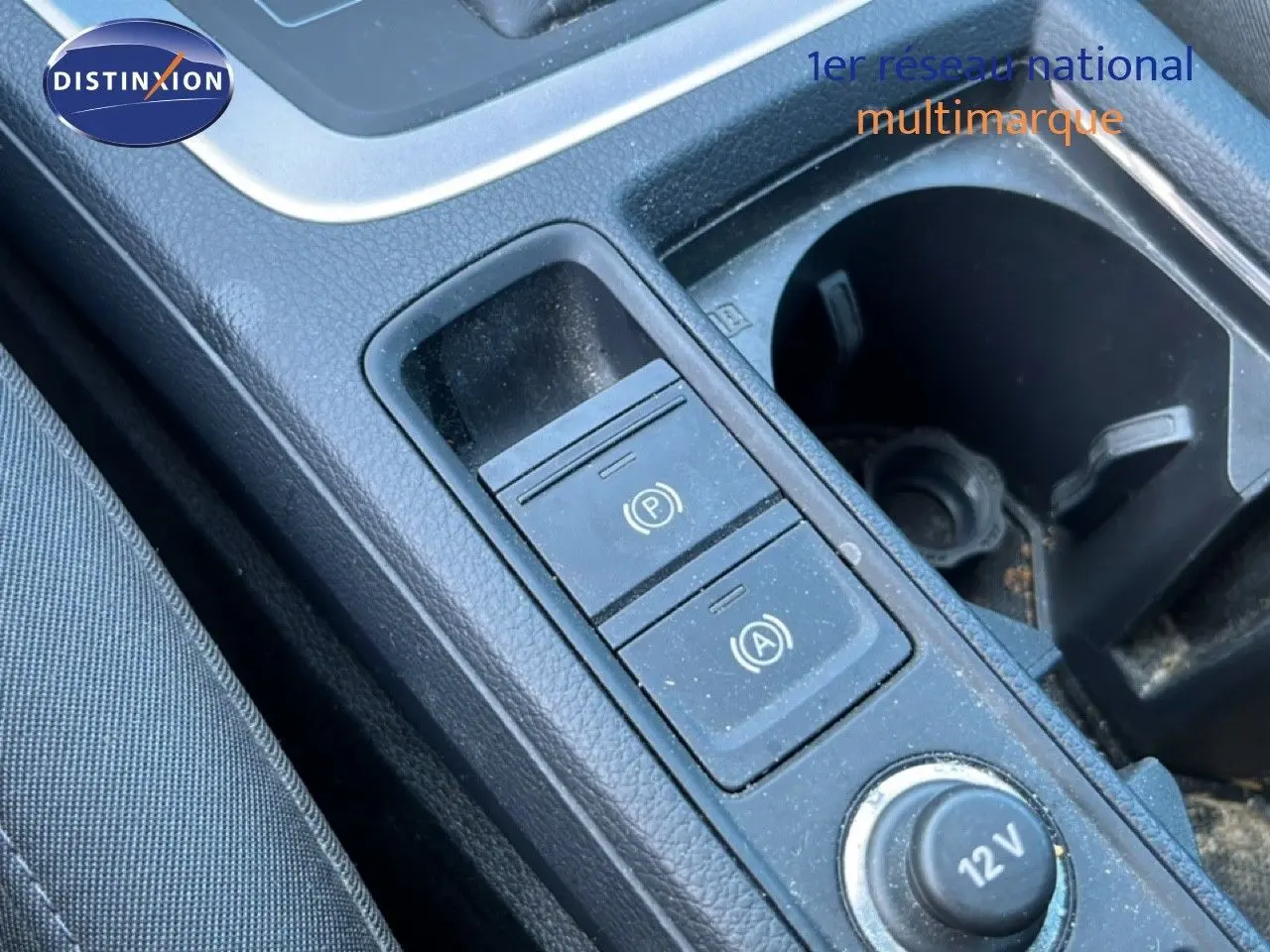 Gros plan sur la console centrale noire de l'Audi Q3 Sportback 35 TDI 2022, montrant les boutons de frein à main et arrêt auto.