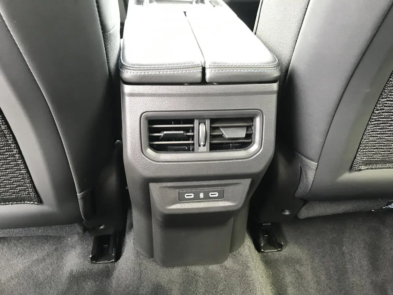 Vue rapprochée de la console centrale arrière noire avec bouches d’aération et ports USB du Renault Austral 2025.