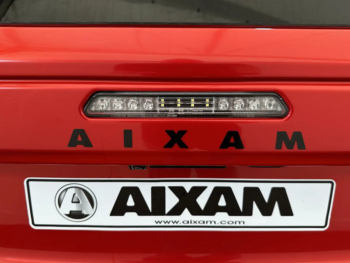 Gros plan sur l'arrière rouge de l'AIXAM AMBITION E CITY PACK 2026 avec feu stop LED et logo AIXAM noir.