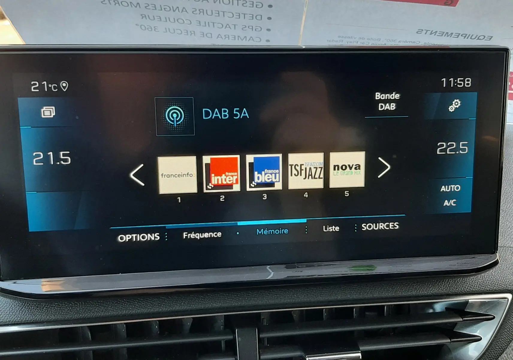 Écran tactile central du Peugeot 3008 2023 affichant les stations radio DAB, avec commandes climatisation et ventilation visibles en dessous.