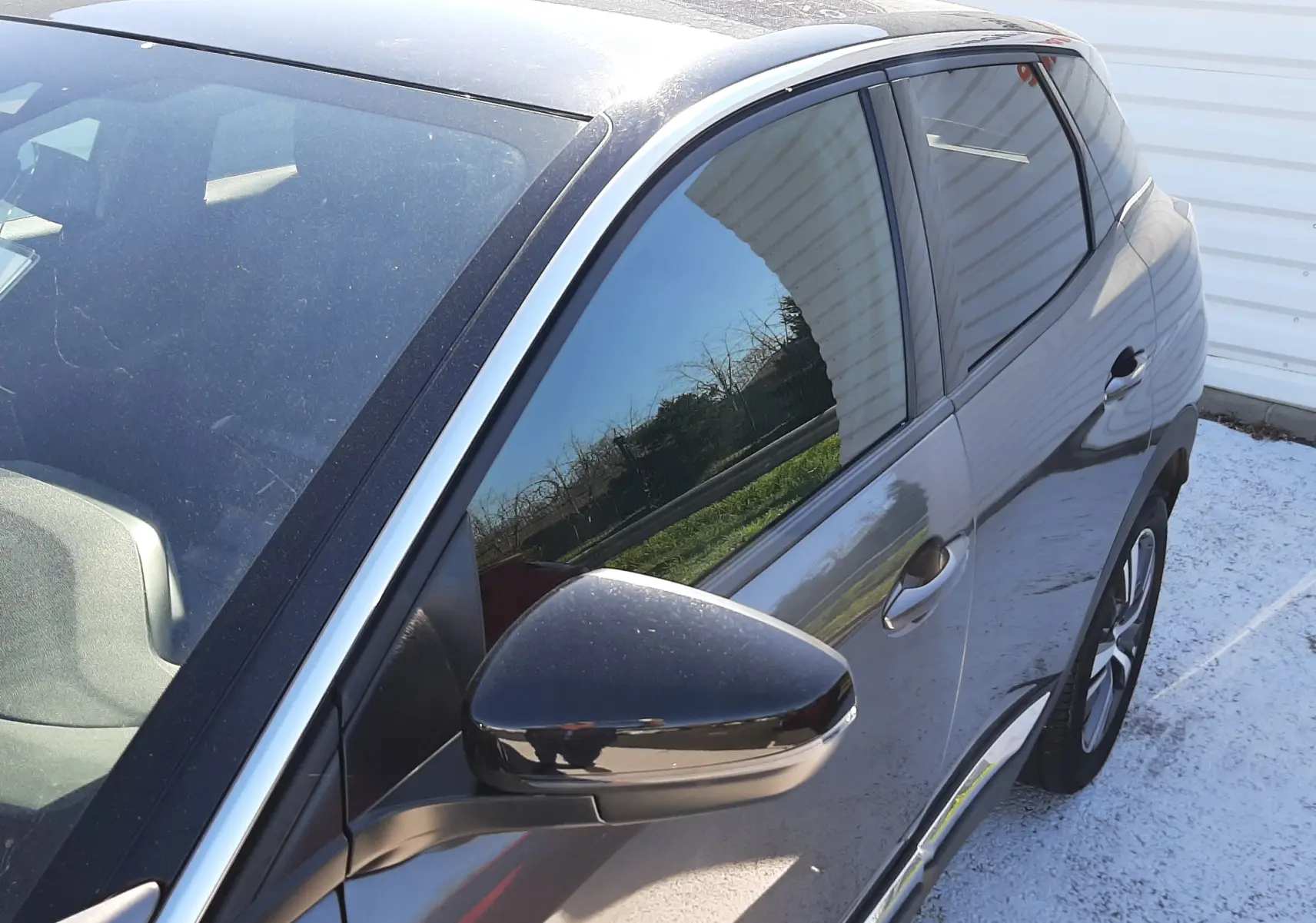 Vue 3/4 avant droit du Peugeot 3008 gris platinium black diamond, avec rétroviseur noir brillant et jantes visibles.