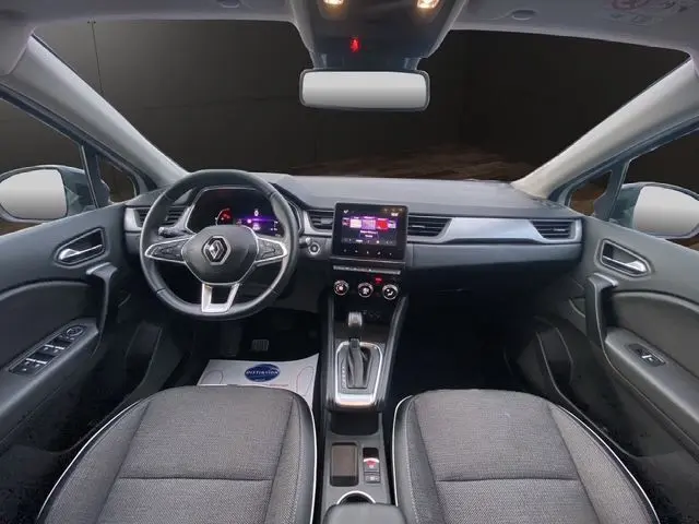 Vue intérieure avant du Renault Captur 2021 DCI 115 EDC Intens, tableau de bord gris noir avec écran tactile central et volant multifonction.