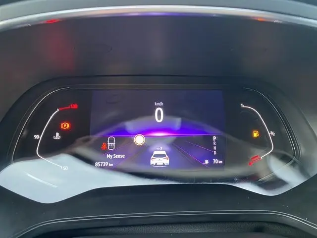 Vue rapprochée du tableau de bord numérique du Renault Captur DCI 115 EDC Intens 2021, affichant la vitesse à 0 km/h et diverses alertes.
