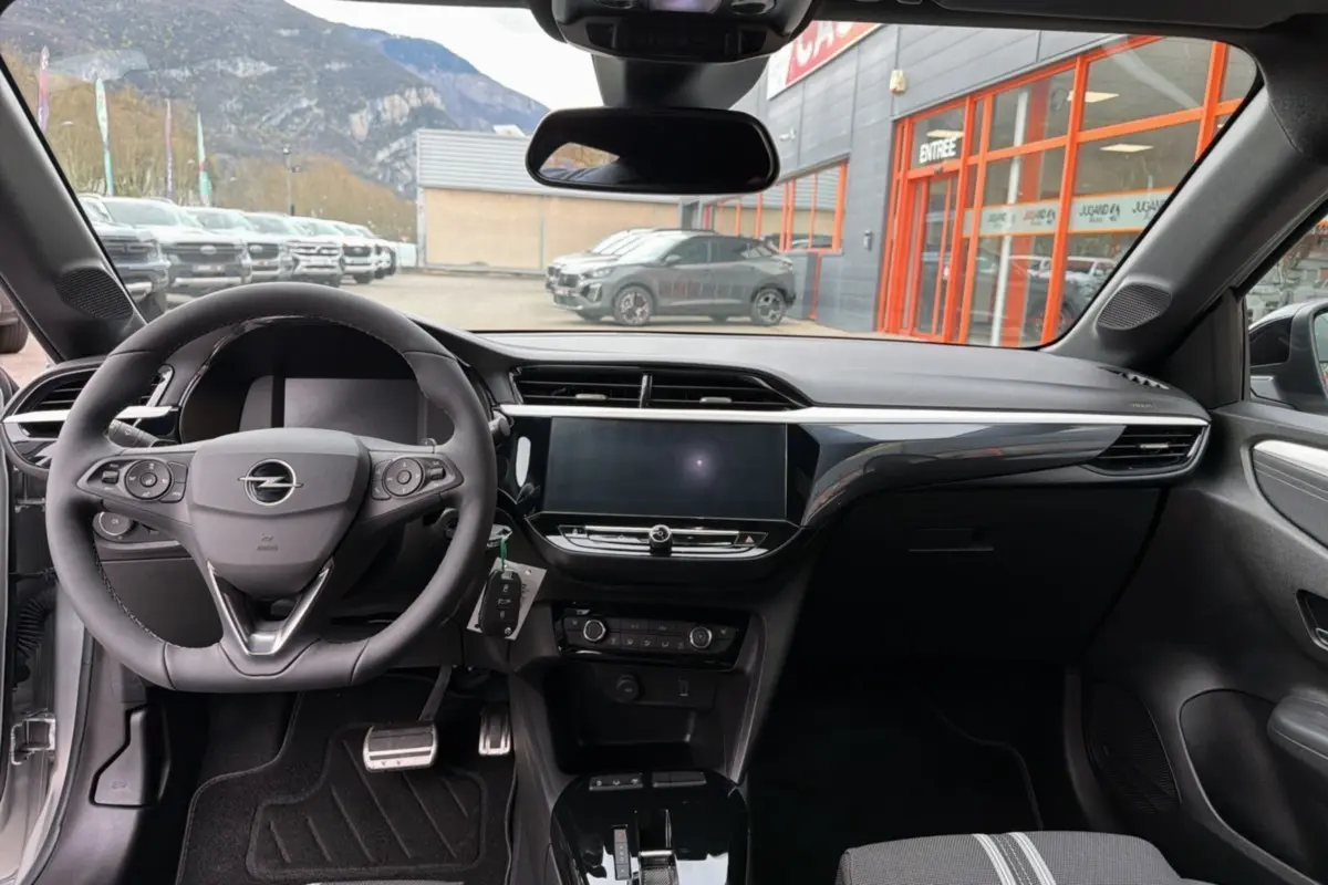 Vue intérieure avant de l’Opel Corsa Hybrid 110 e-DCT6 gris kristall, volant cuir multifonctions et écran tactile 10 pouces.