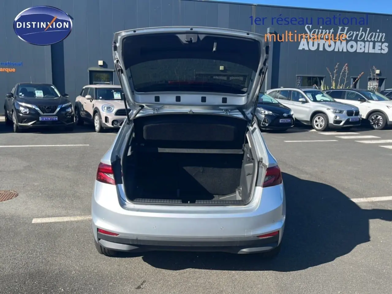 Vue arrière d'une Skoda Fabia 2025 Reflex Silver Metal avec coffre ouvert sur un parking extérieur.