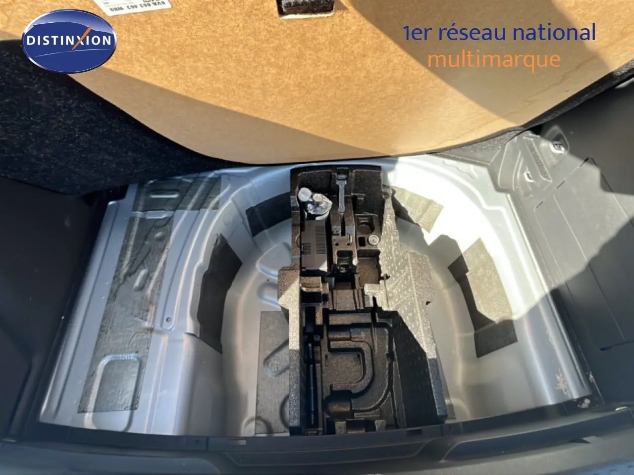 Vue plongeante sur le coffre ouvert d'une Skoda Fabia Reflex Silver Metal, montrant le rangement sous plancher sans roue de secours.