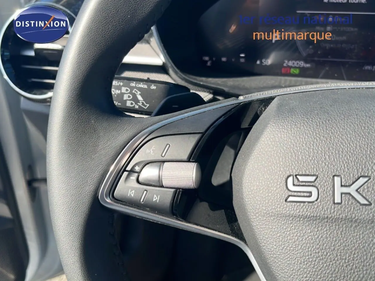 Gros plan sur la partie gauche du volant noir de la Skoda Fabia 2025, avec commandes audio intégrées.