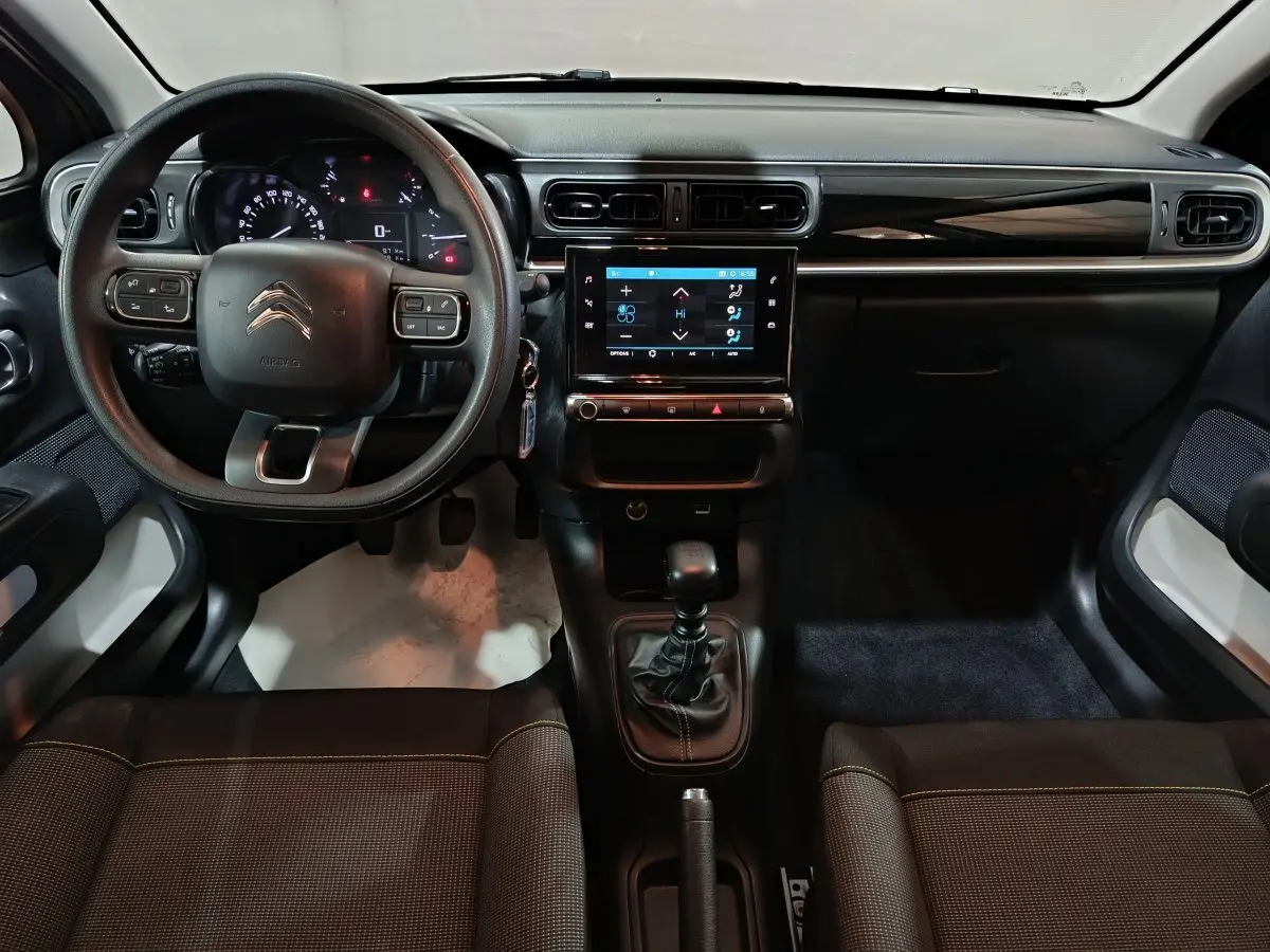 Vue intérieure frontale du tableau de bord de la Citroën C3 2024 avec volant multifonctions et écran tactile central.