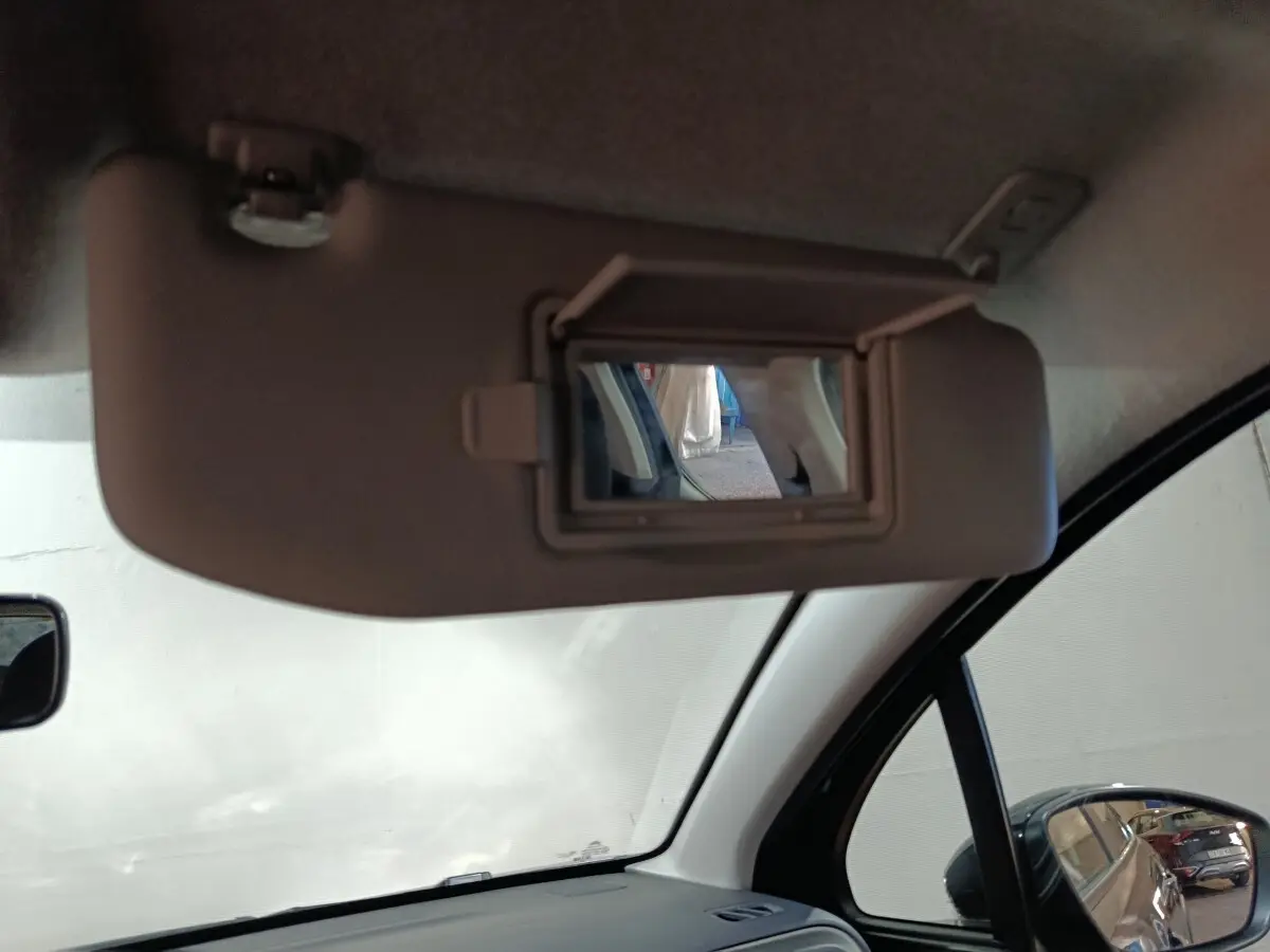Miroir de courtoisie ouvert sur le pare-soleil côté conducteur à l'intérieur d'une Citroën C3 2024 gris foncé.