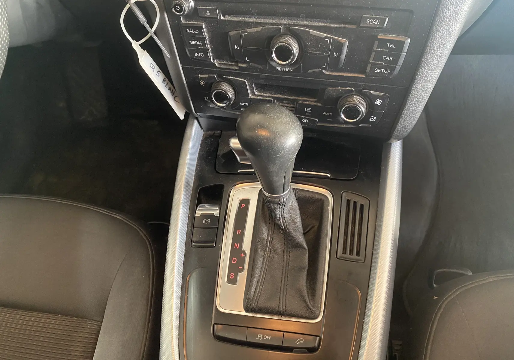 Vue rapprochée de la console centrale de l'Audi Q5 blanche 2012, avec levier de vitesse automatique et commandes audio.