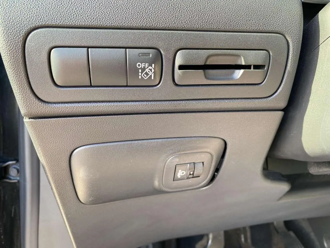 Vue rapprochée des commandes d'assistance et réglage des projecteurs côté conducteur du Citroën C3 Aircross noir 2023.