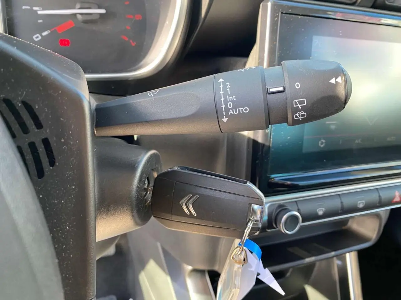 Gros plan sur la clé de contact et le commodo d'essuie-glace du tableau de bord d'une Citroën C3 Aircross 2023.