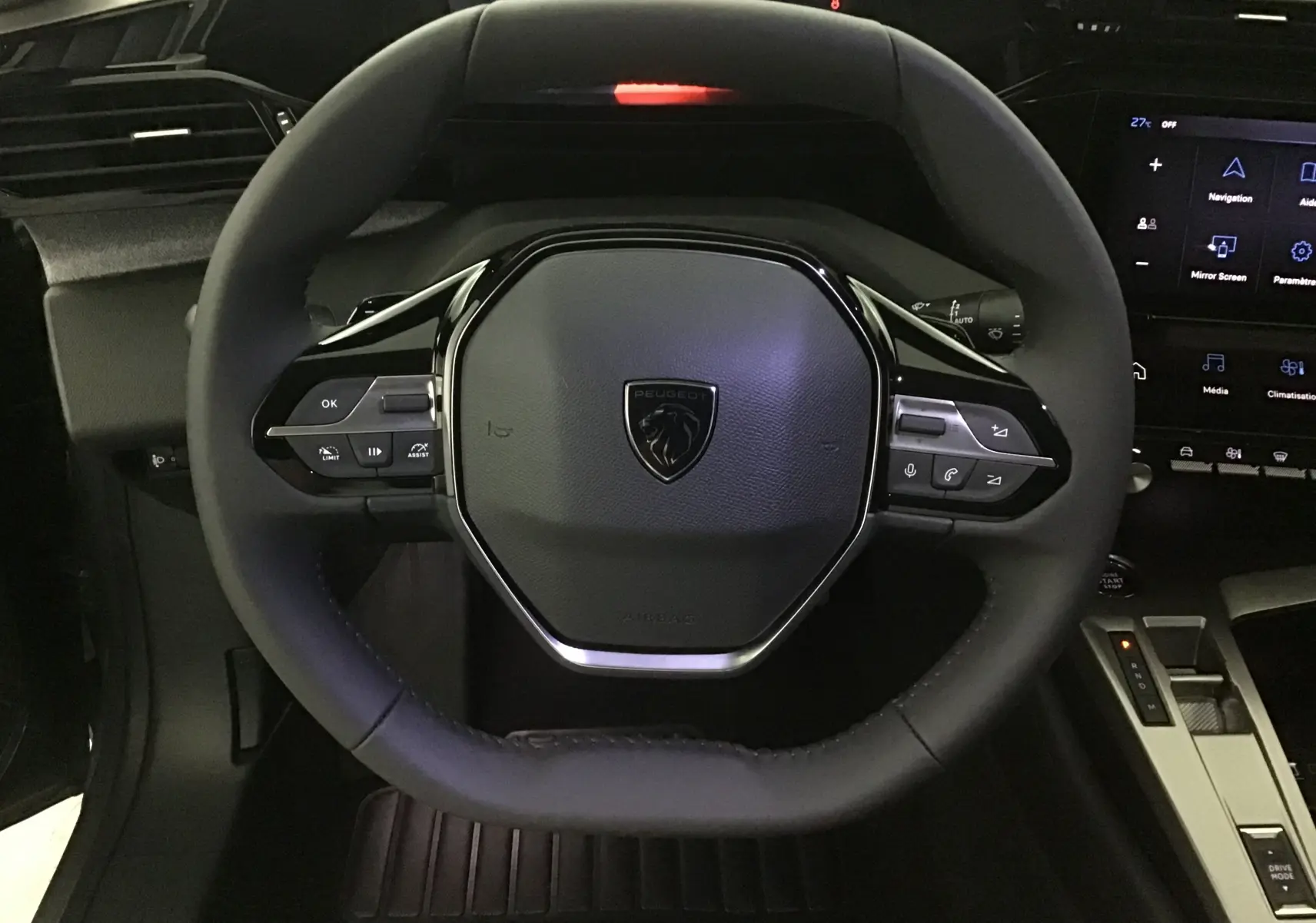 Vue rapprochée du volant cuir noir de la Peugeot 308 2025 avec commandes intégrées et tableau de bord numérique.