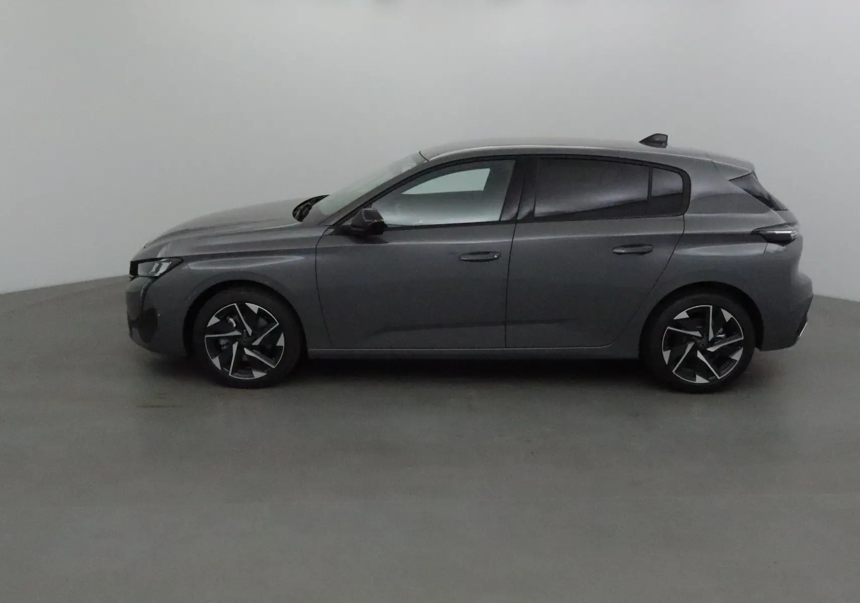 Peugeot 308 gris Sellenium vue de profil côté gauche, avec jantes alliage noires et lignes modernes.