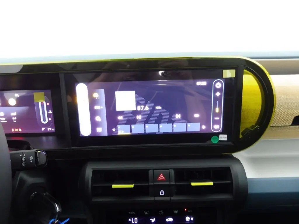 Écran tactile central et tableau de bord de la Fiat Grande Panda 1.2 Hybrid 2025 en bronze luna, intérieur moderne avec touches jaunes.