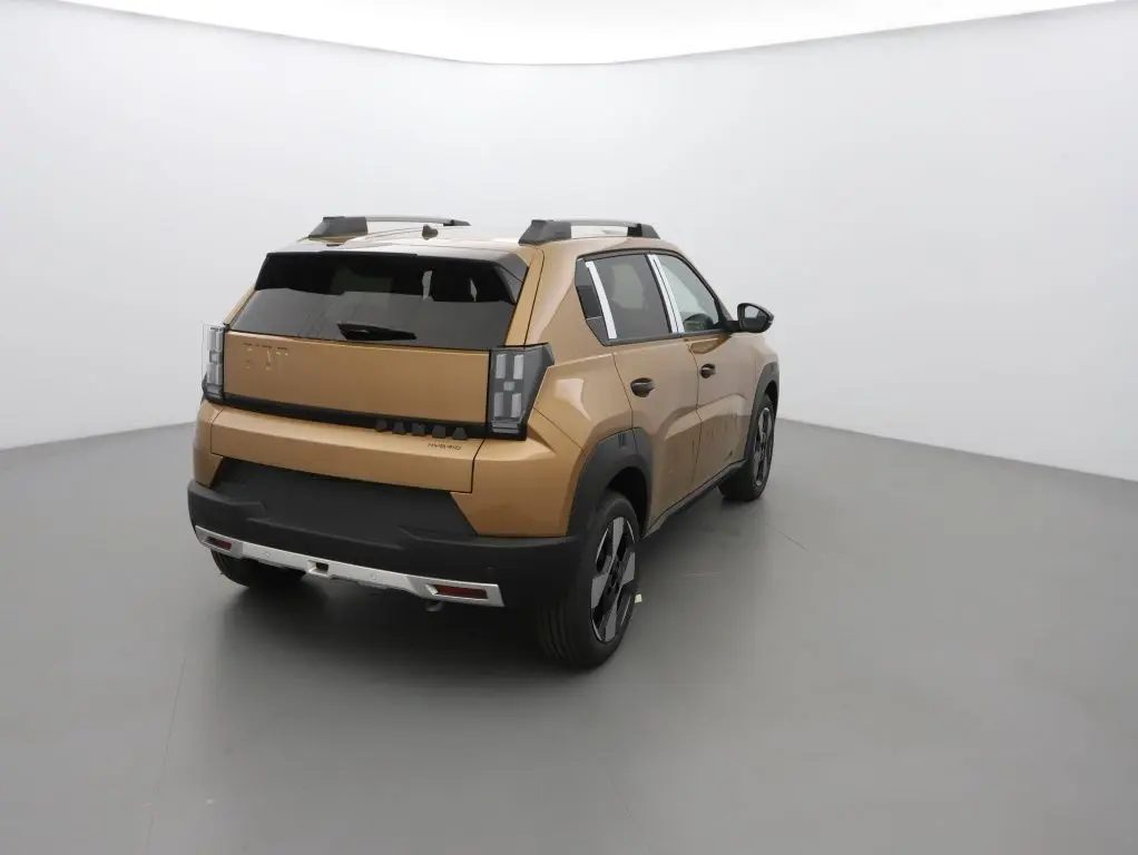 Vue 3/4 arrière droite d'une FIAT Grande Panda 2025 en bronze luna avec toit noir et barres de toit noires.