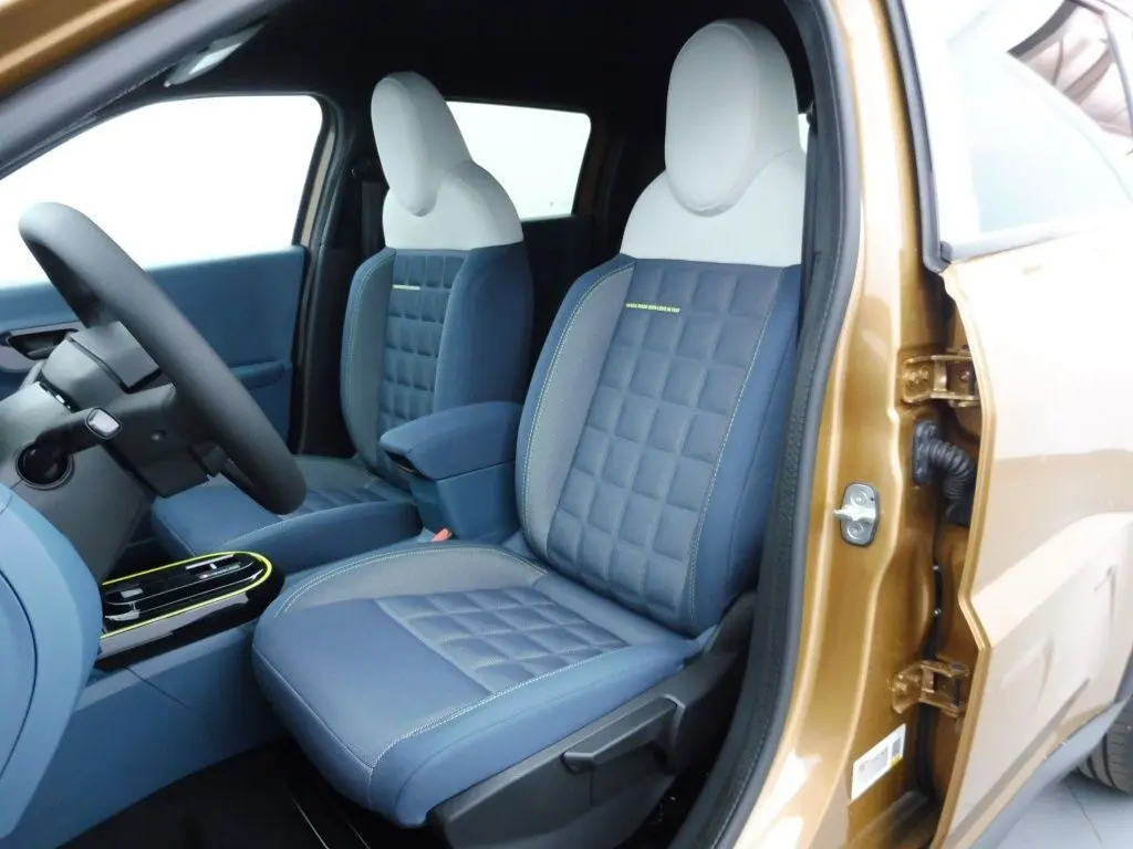 Vue intérieure côté conducteur de la FIAT Grande Panda 2025 en bronze luna, sièges bi-ton bleu et blanc avec surpiqûres.