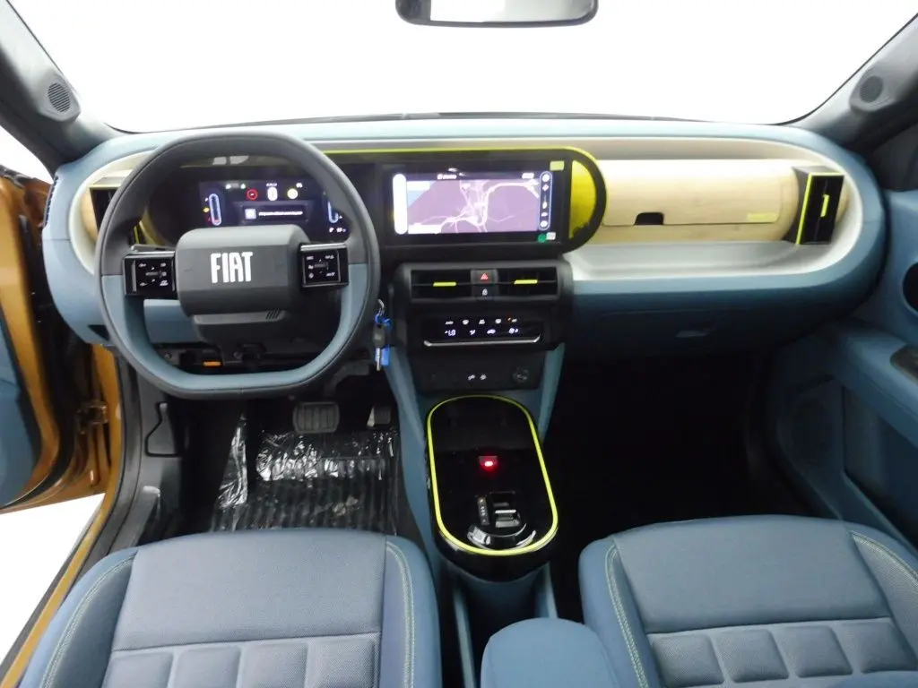 Vue intérieure avant de la Fiat Grande Panda bronze luna 2025, tableau de bord moderne avec écran tactile et volant multifonction.