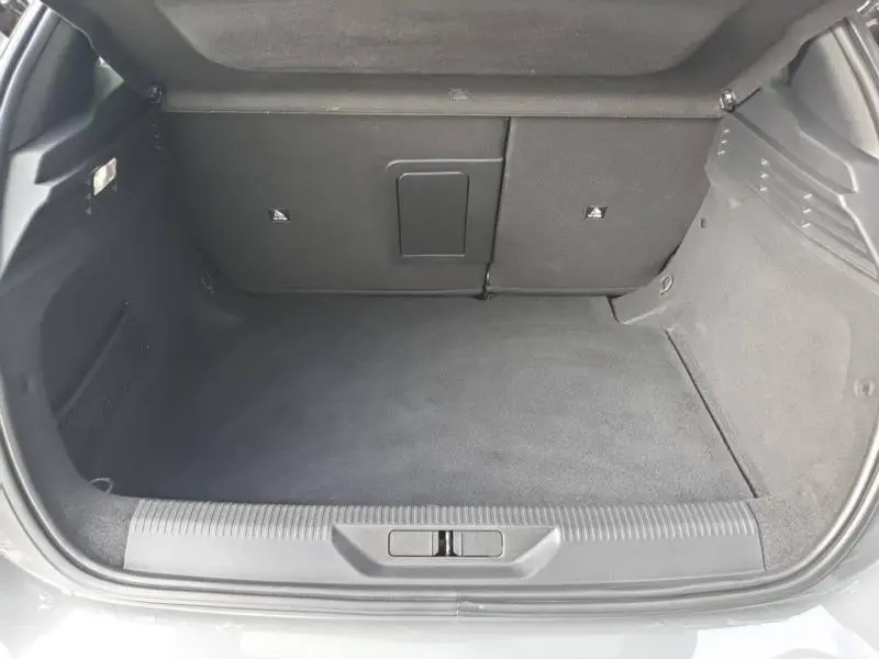 Coffre spacieux de Peugeot 308 2024 gris Sélénium, vue de l'arrière avec banquette rabattable et trappe à skis.