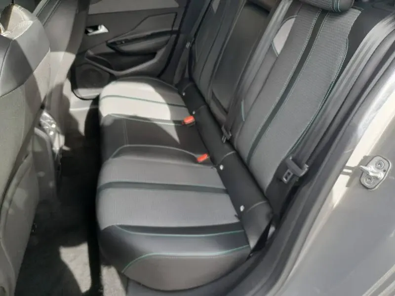 Vue latérale droite de la banquette arrière en tissu et cuir noir avec surpiqûres vertes d'une Peugeot 308 gris Sélénium 2024.