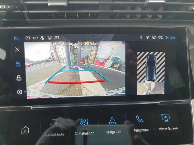 Écran tactile de la Peugeot 308 gris Sélénium montrant la caméra de recul et l'aide au stationnement en vue arrière.