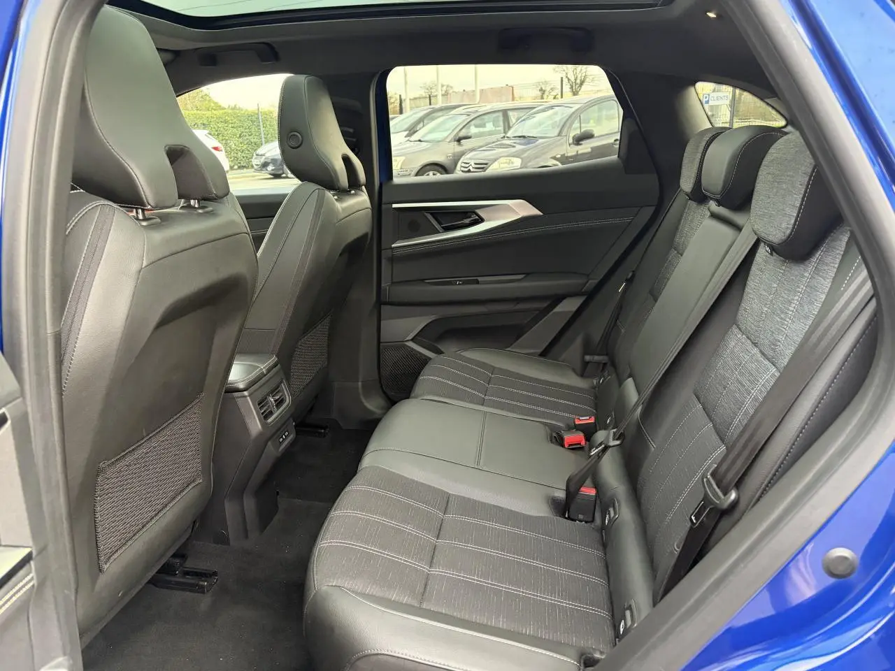 Vue intérieure côté droit de la banquette arrière grise et noire du Renault Austral E-Tech Bleu Iron avec porte ouverte.