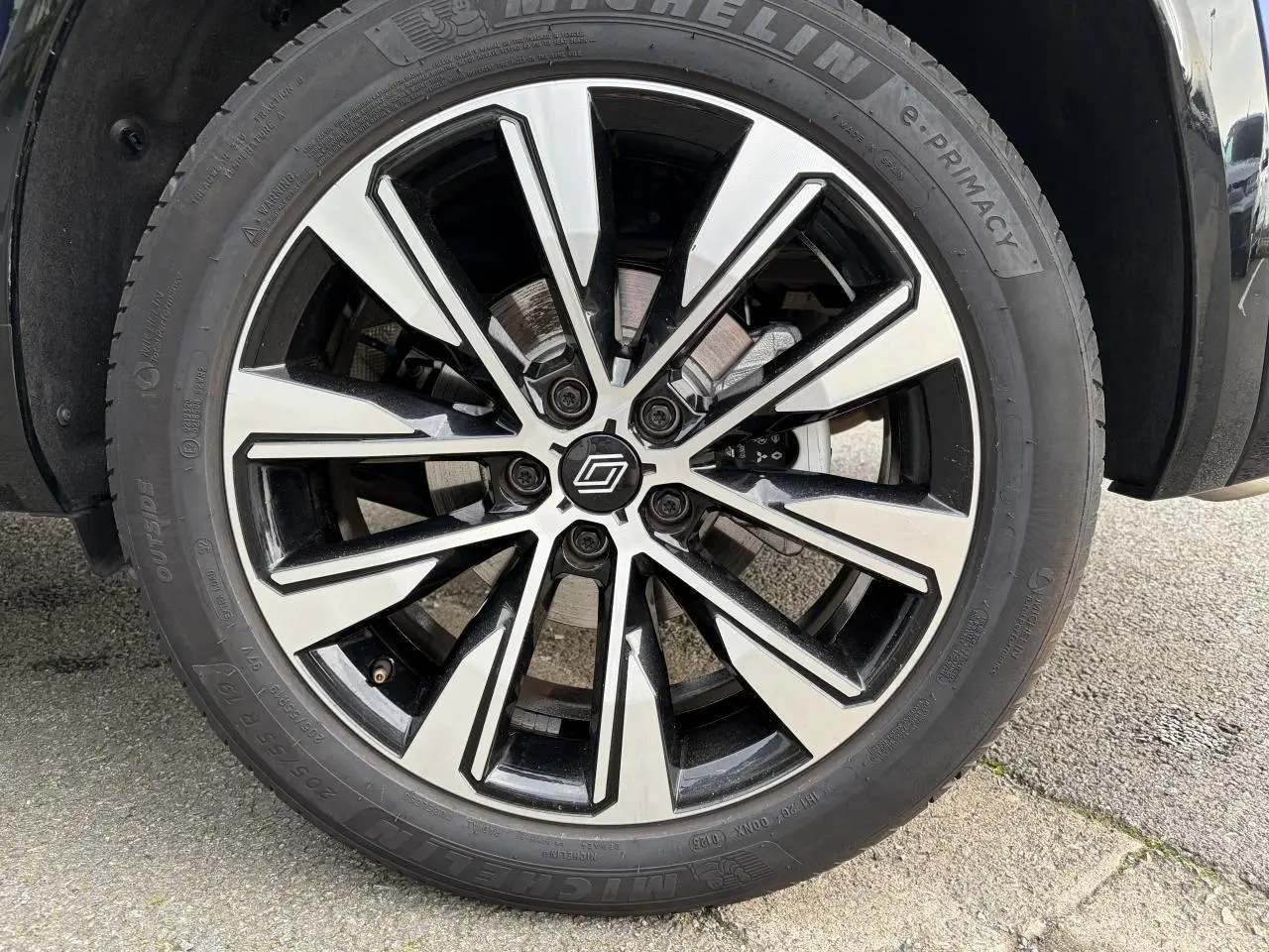 Gros plan sur la jante alliage 19 pouces diamantée noire du Renault Austral E-Tech Bleu Iron, roue avant droite.