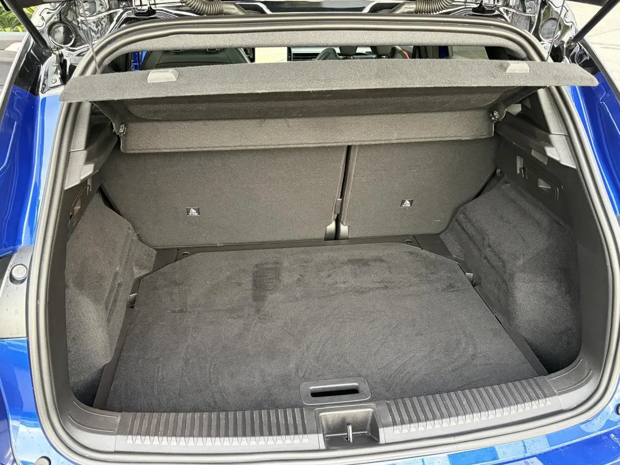 Coffre ouvert du Renault Austral E-Tech bleu Iron, vue plongeante montrant l'espace de rangement intérieur.