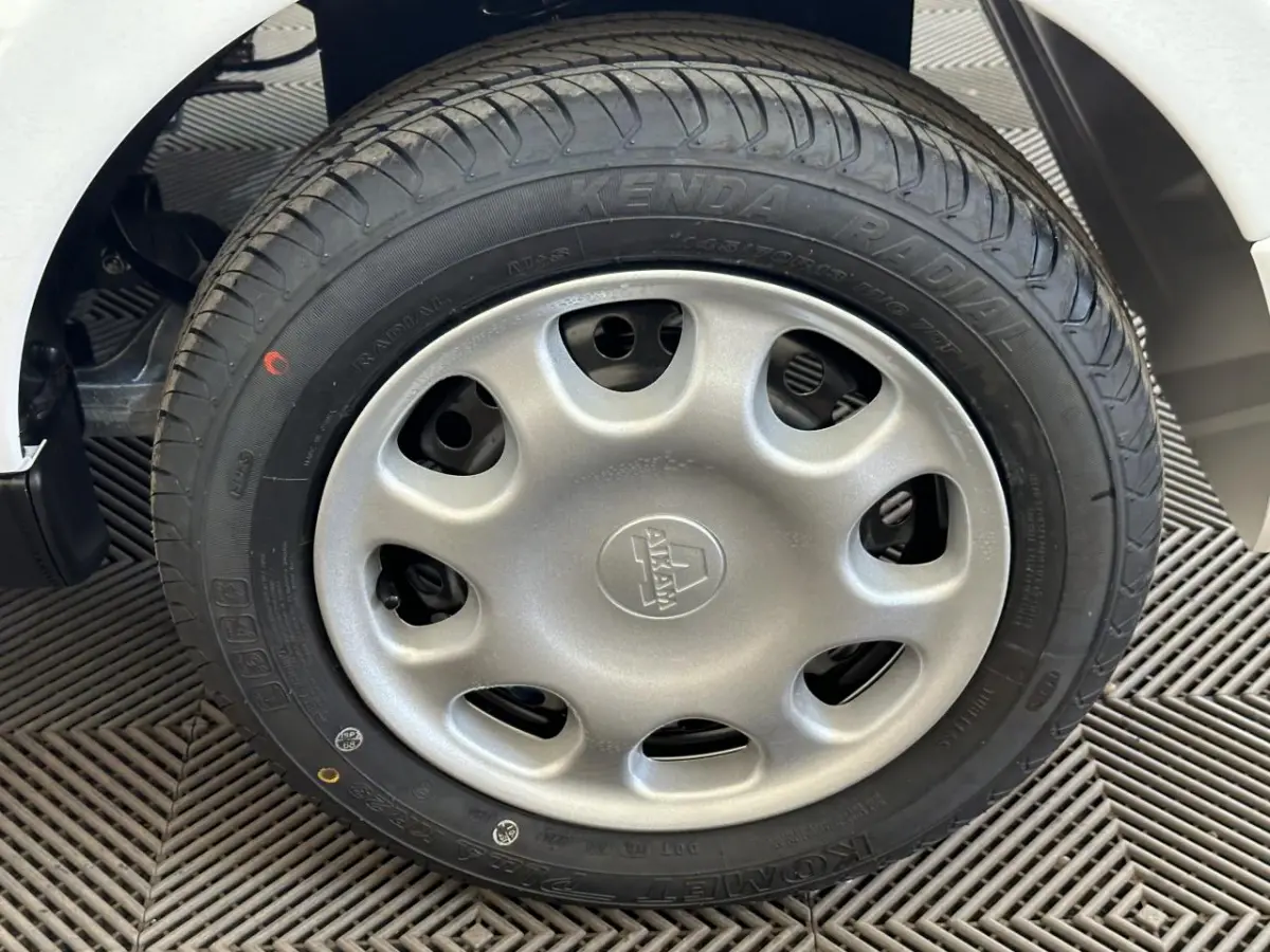 Gros plan sur la roue arrière droite d'une Aixam Minauto E Access blanche 2026 avec pneu et passage de roue visible.