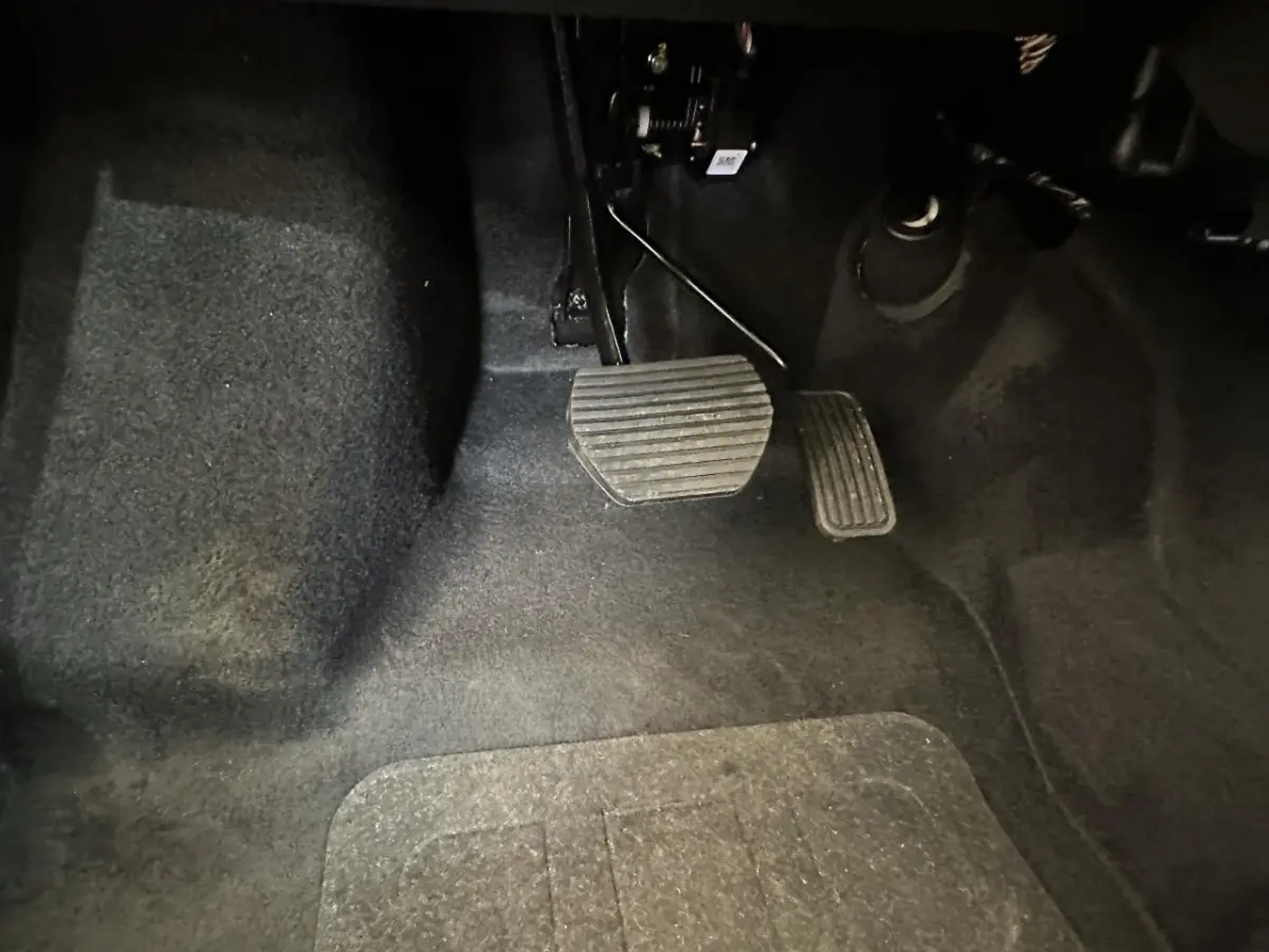 Gros plan sur les pédales d'accélérateur et de frein de l'AIXAM MINAUTO E ACCESS 2026, intérieur noir.