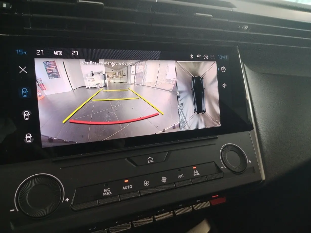 Écran tactile intérieur montrant la caméra de recul et la vue 360° du Peugeot 308 SW gris Artense en stationnement.