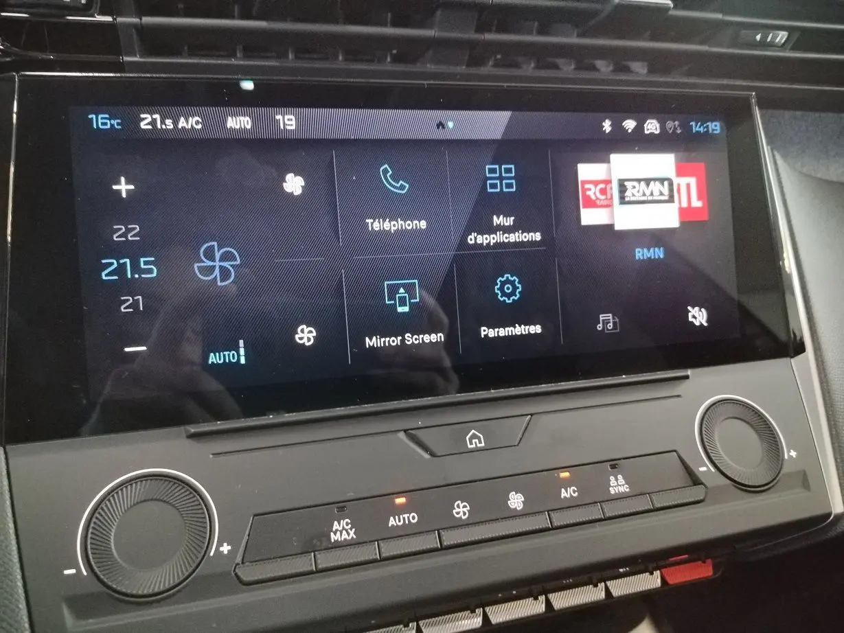 Vue rapprochée de l’écran tactile central et des commandes de climatisation du Peugeot 308 SW Hybrid gris Artense.