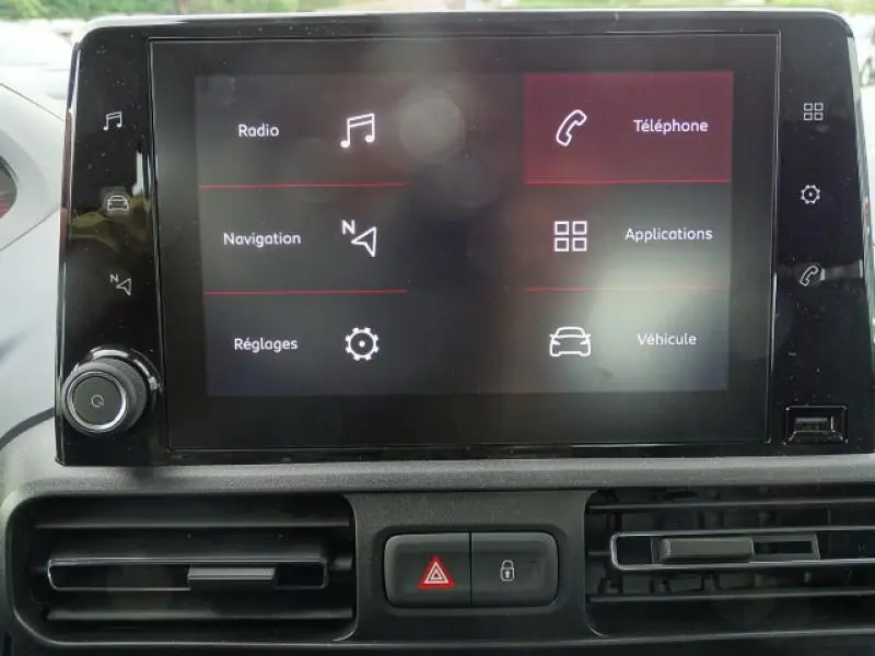 Écran tactile central du PEUGEOT RIFTER 2019 affichant les menus radio, navigation, téléphone et réglages, avec aérateurs en dessous.