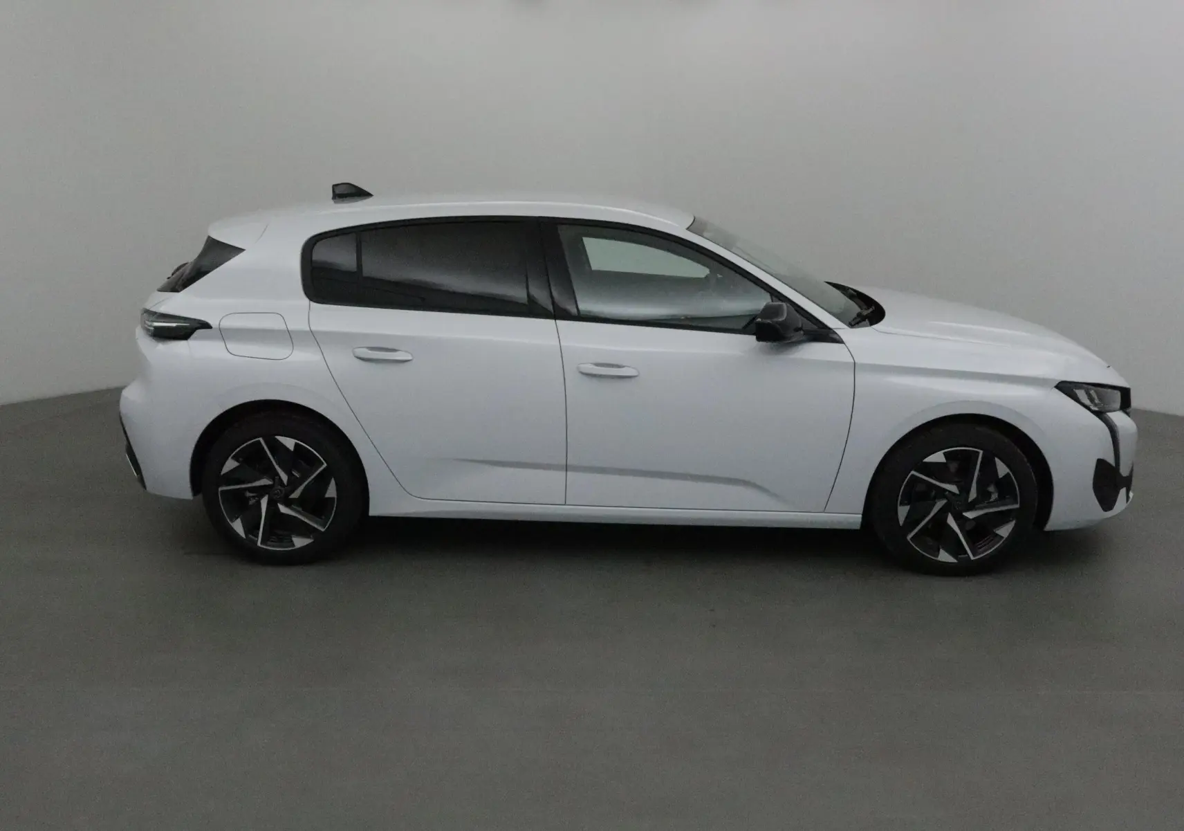 Profil côté droit d'une Peugeot 308 blanche Okenite 2025 avec jantes alliage et vitres teintées.