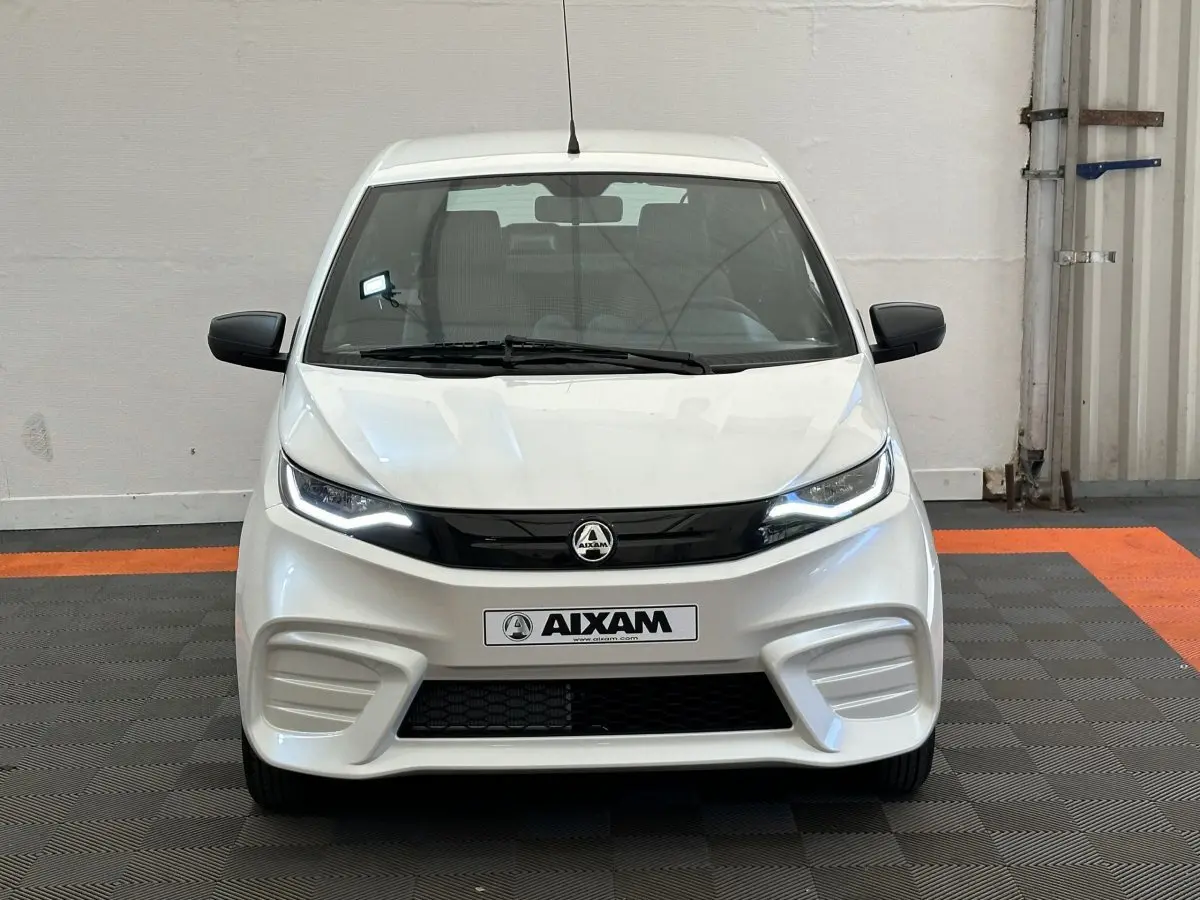 Vue frontale d'une Aixam Ambition E City Pack blanche 2026 avec phares LED et rétroviseurs noirs.