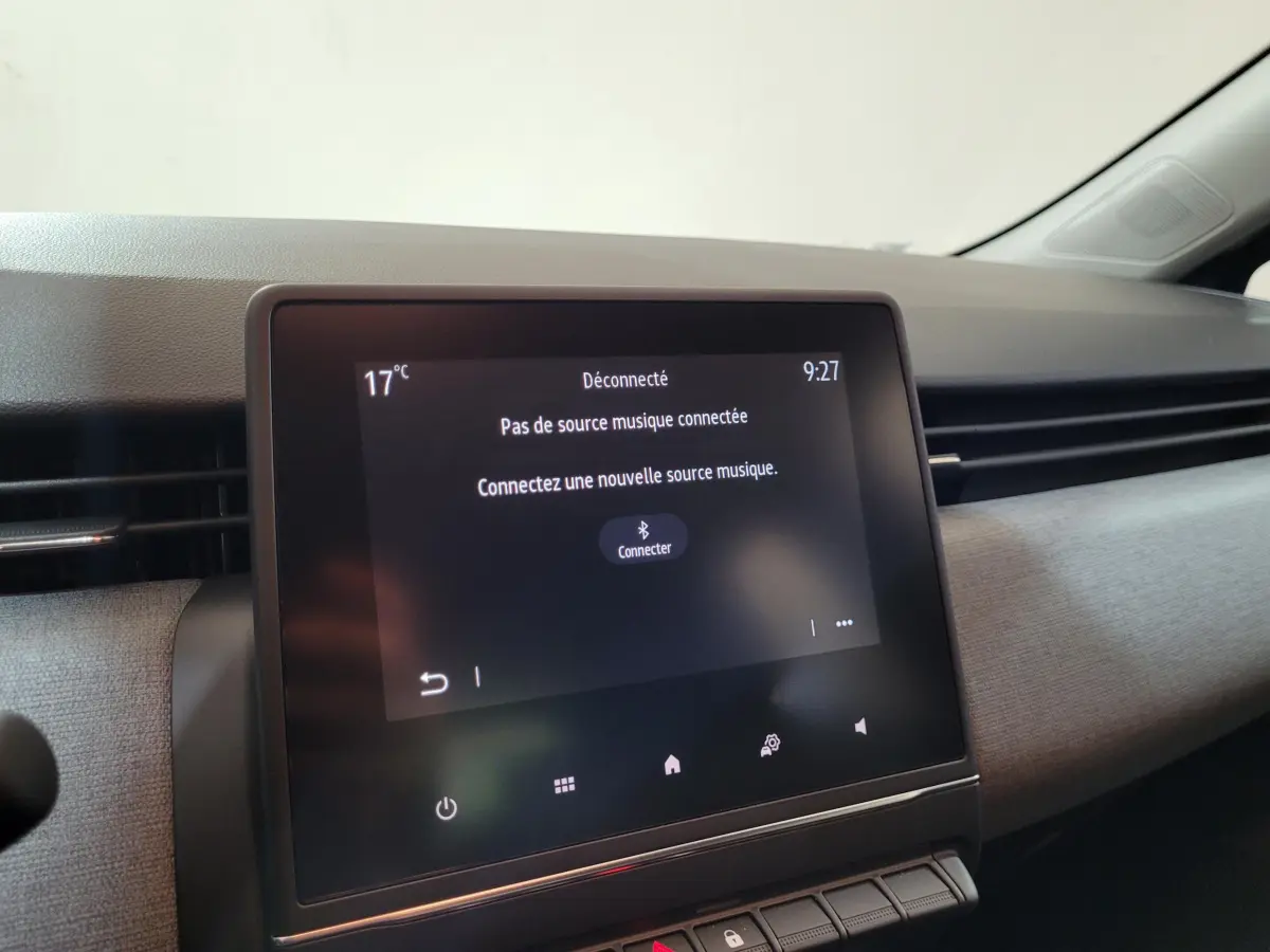 Écran tactile central de la Renault Clio gris foncé, vue rapprochée de l’intérieur côté passager.