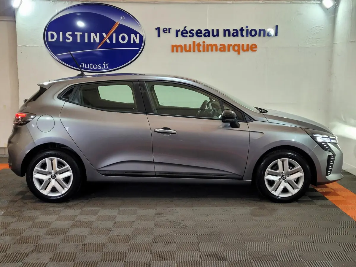 Profil droit d'une Renault Clio gris foncé 2025 avec feux LED et jantes alliage cinq branches.