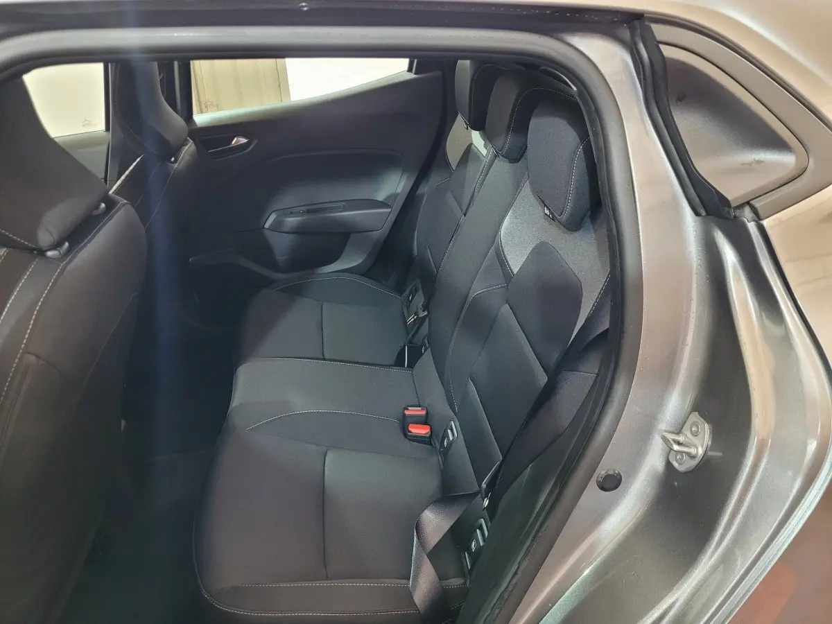 Vue intérieure côté droit sur la banquette arrière noire d’une Renault Clio gris foncé avec ceinture de sécurité visible.
