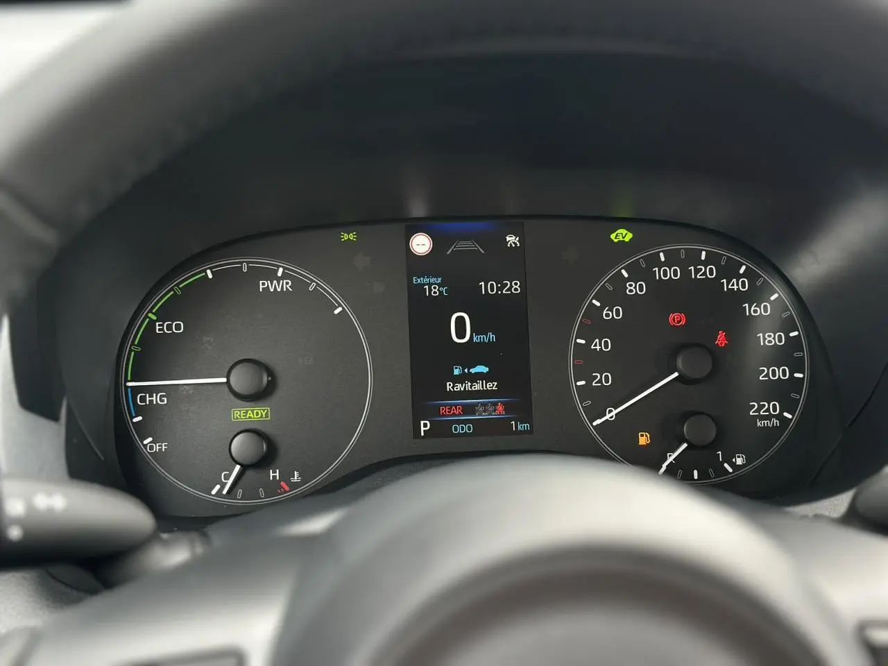 Vue rapprochée du tableau de bord de la Toyota Yaris hybride 2025, affichage numérique et compteurs analogiques.