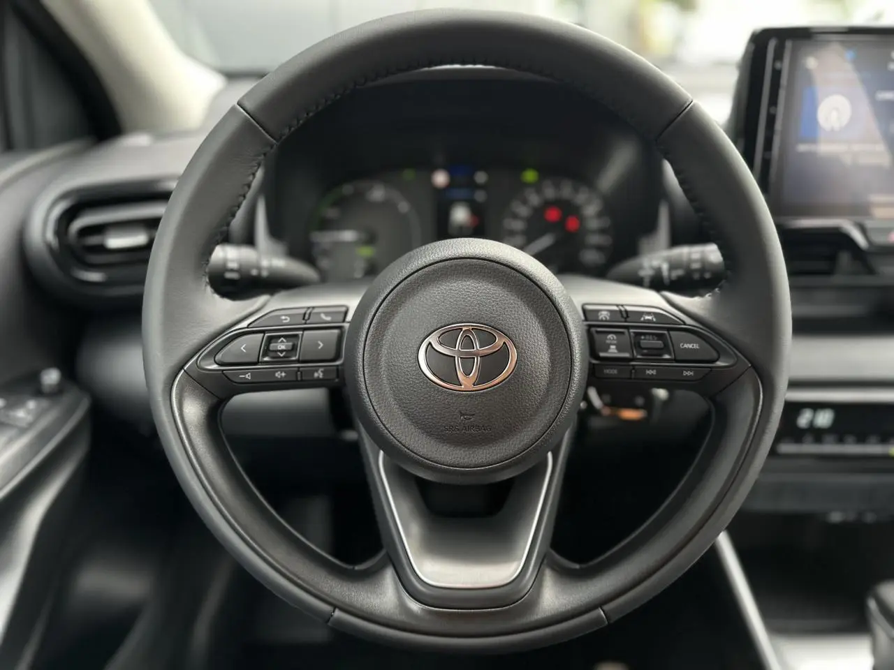 Volant en cuir noir de Toyota Yaris 2025 Hybride, vue frontale centrée sur les commandes multifonctions.
